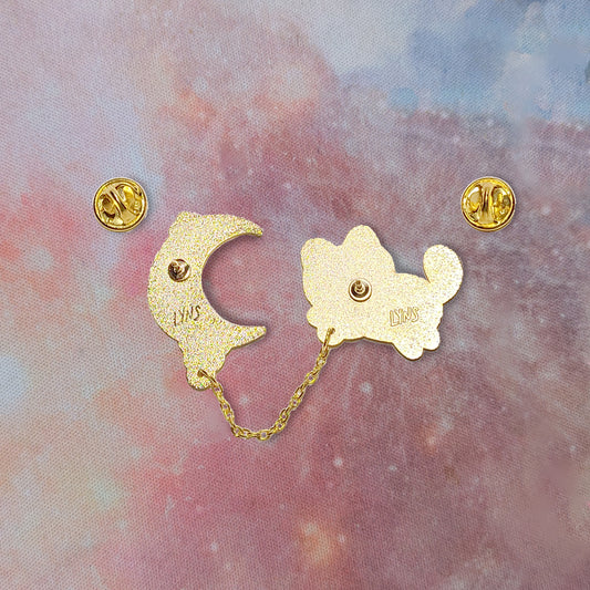 Gold enamel pin backs with Lyns engraving on a colorful background