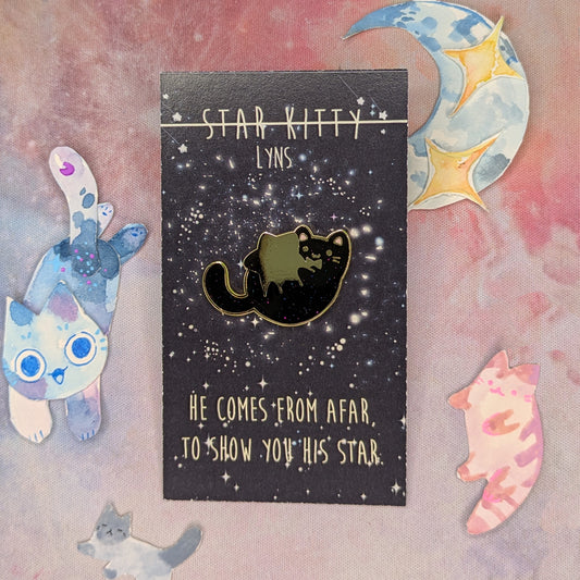 Cat holding star enamel pin on a decorative card with celestial designs
